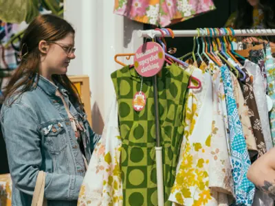 Patron looking at different clothing options provided by a Gaukel Block vendor