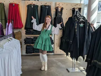 Woman standing in shop with items on display behind her